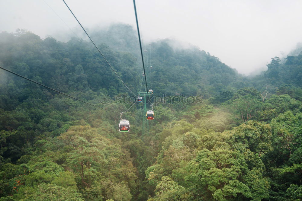 Similar – Chairlift with empty 2-seater chair and view of snow-free hill country