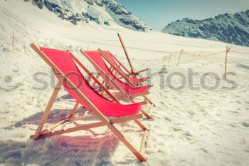 Similar – Sun loungers in the snow in front of mountain panorama