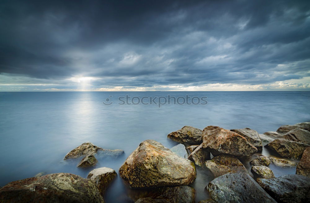 Similar – Rocks washed by the sea, with sky with sunset atmosphere