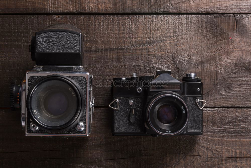 Similar – analogue 35mm camera on brown wooden table