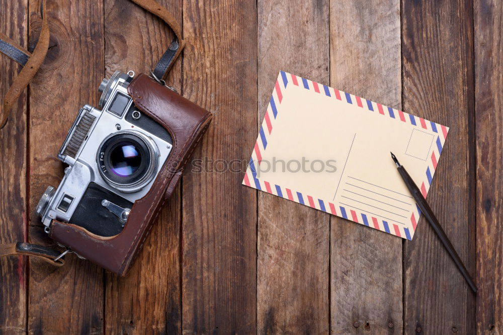 Camera, glasses and notepad on wood