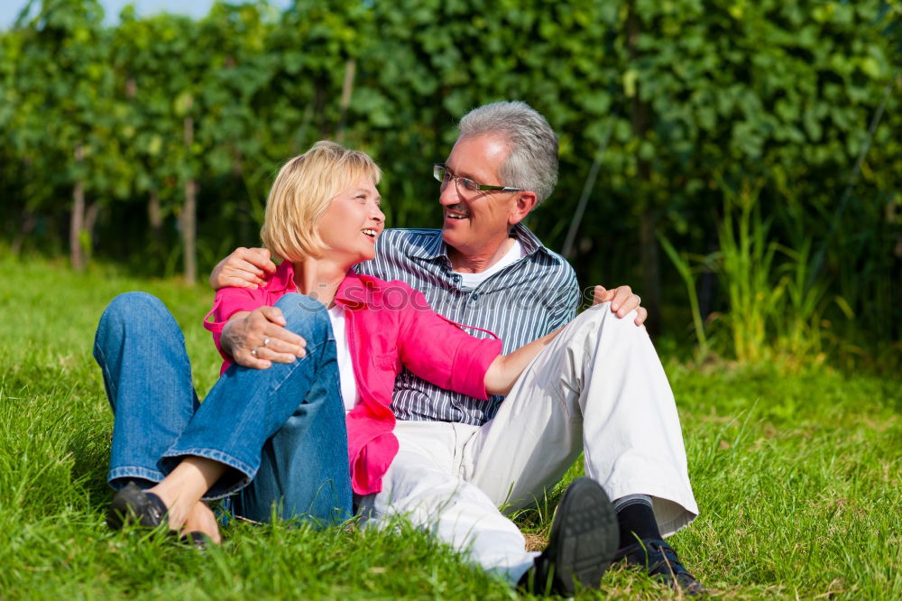 Similar – Image, Stock Photo 2 seniors in love are sitting on a bench in the vineyard and look into the Ahr valley. The man points to something.