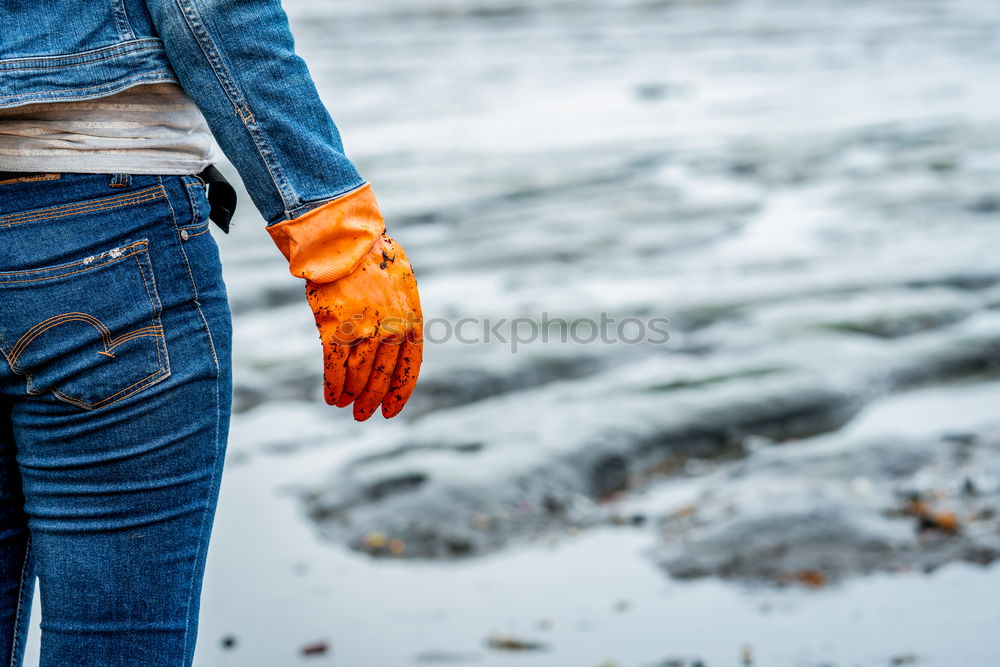 Image, Stock Photo Volunteers wear jeans and long sleeved shirts and wear orange rubber gloves to collect garbage on the beach. Beach environment. Woman cleaning the beach. Tidying up rubbish on beach.