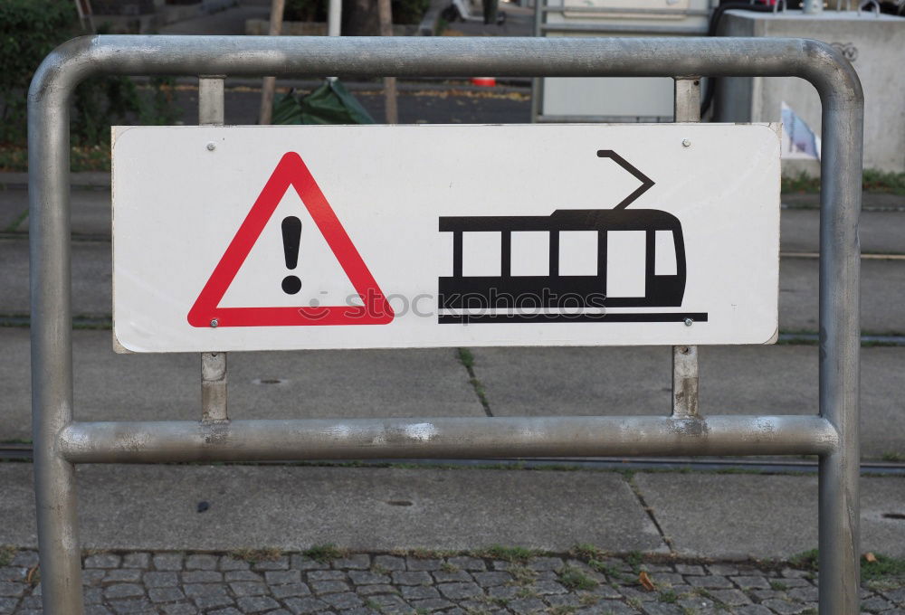 red sprayed warning sign about clearance height on barge in front of construction fence and bushes.