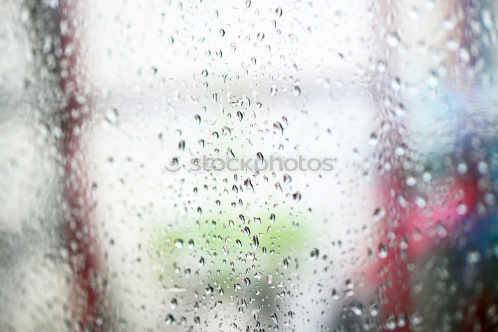 Different vehicles in a traffic jam through the rainy bus glass