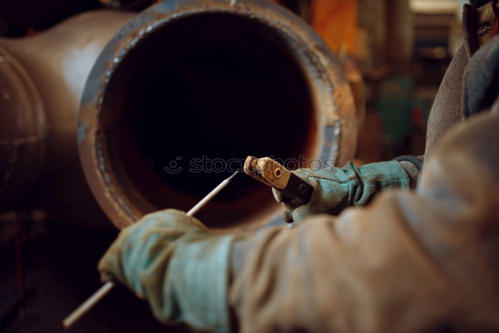 Unrecognizable worker cutting metal in garage