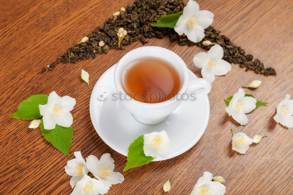 Similar – Black tea with jasmine in a white cup on a brown wooden table