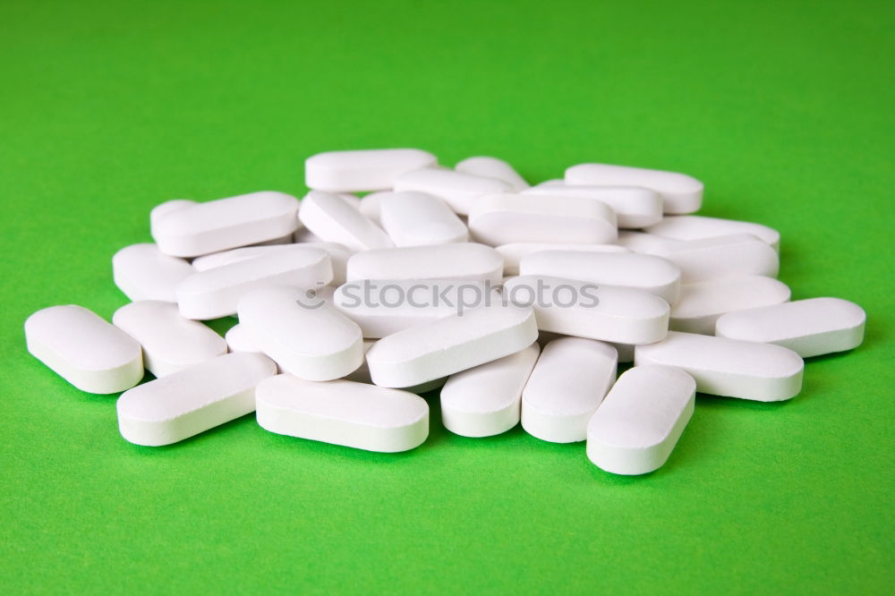 Similar – white plastic can and scattered oval pills