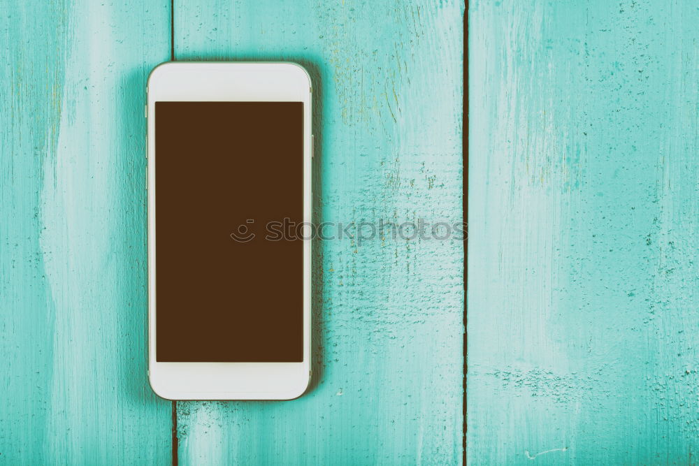 White Mobile Phone With Blank Screen On Wood Table