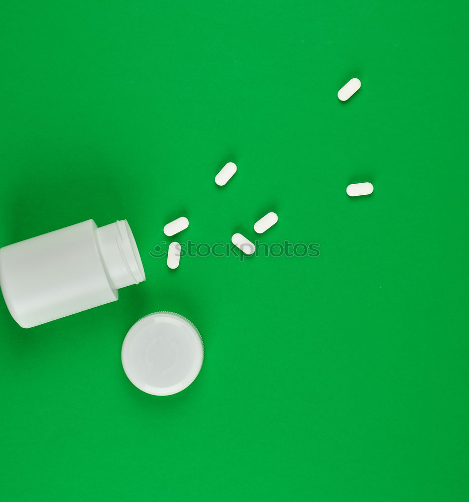 Similar – white plastic can and scattered oval pills