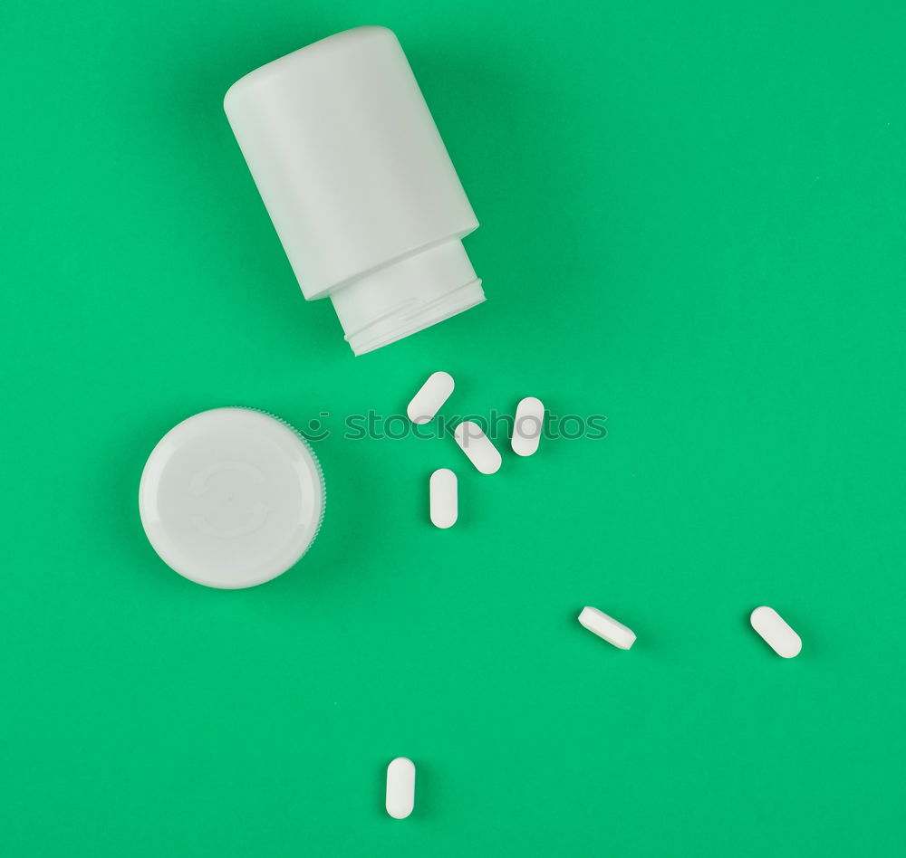 white plastic can and scattered oval pills