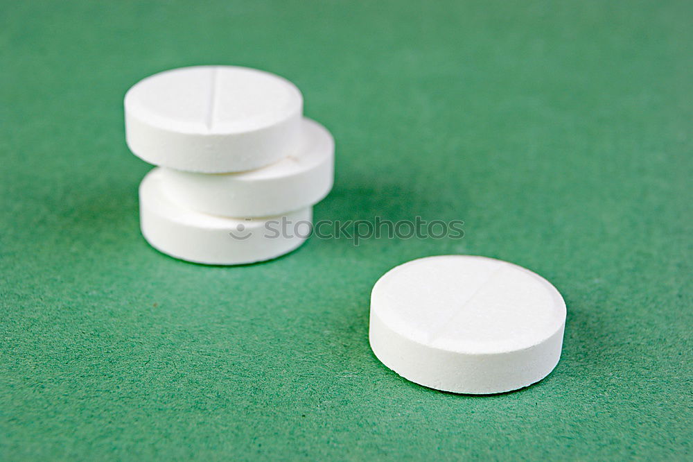 Similar – white plastic can and scattered oval pills