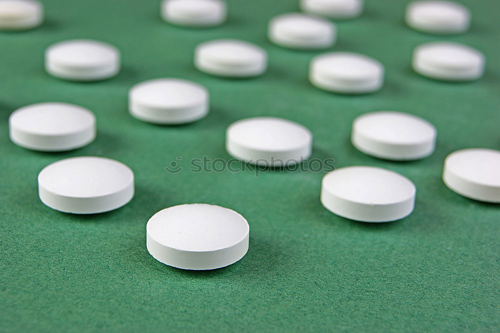 Similar – white plastic can and scattered oval pills