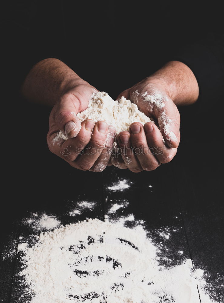 Image, Stock Photo white wheat flour in male hands, black background