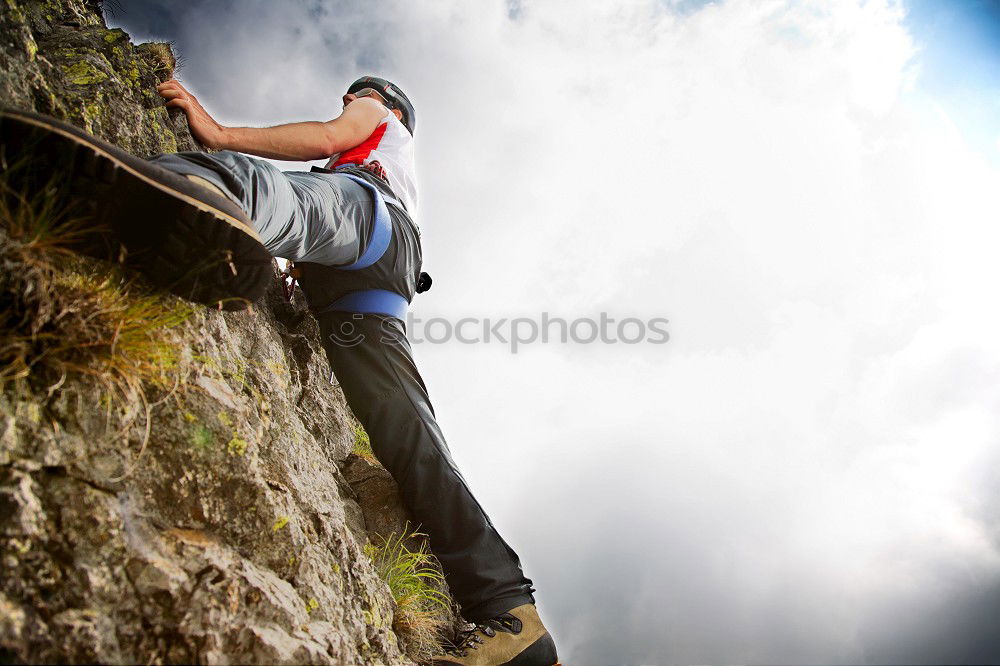 Similar – Rock climber clinging to a cliff.