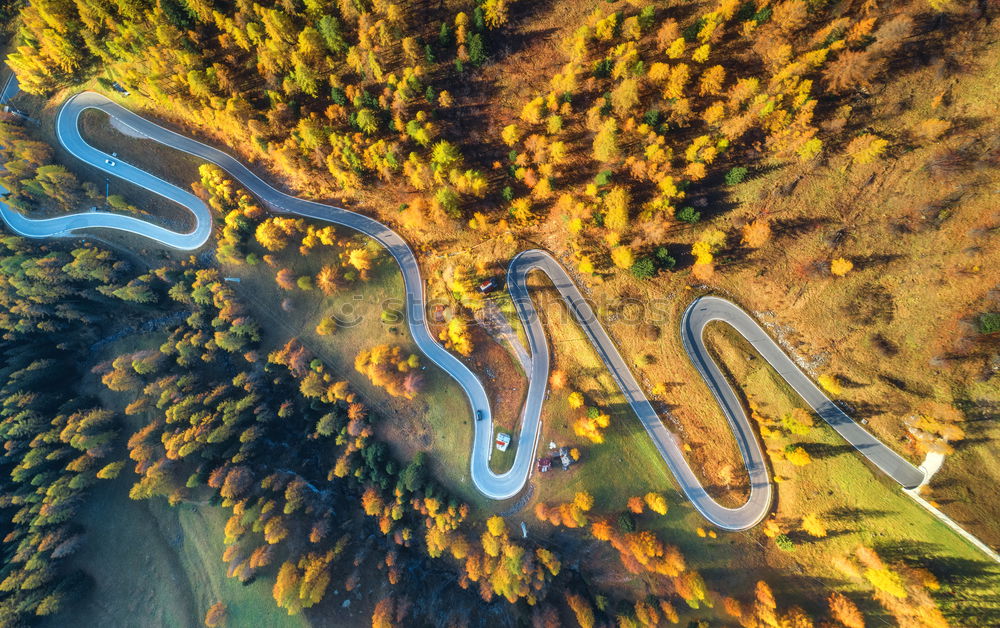 Similar – Curved road in fall forest and village.