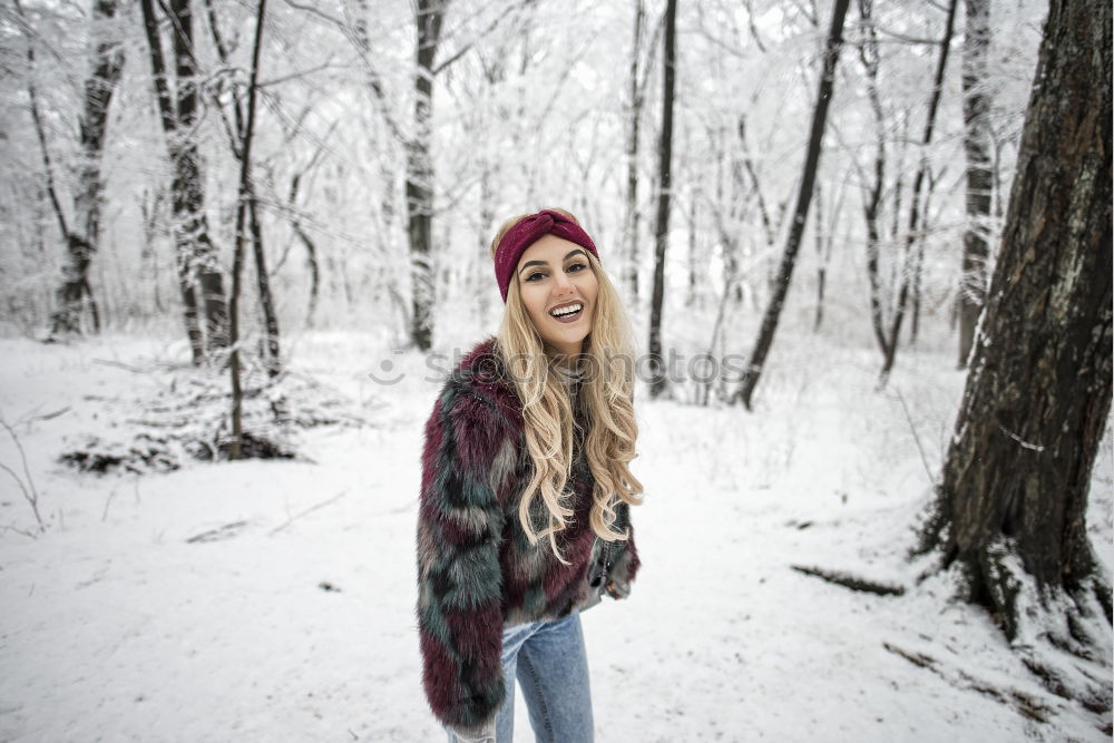 Similar – woman leaning against tree in winter landscape