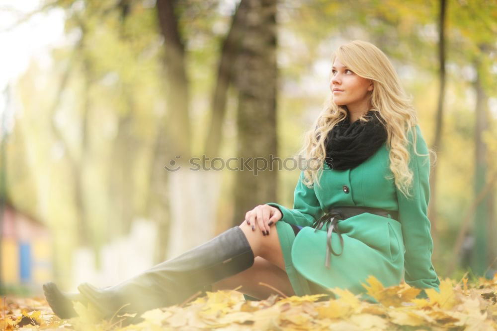 Similar – Young blonde woman sitting on a bench in the street