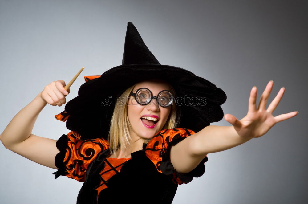 Similar – Beautiful girl disguised of witch decorating a pumpkin at home.