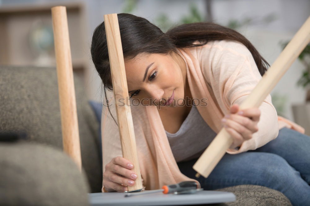 Similar – Asiatische Frau baut einen Tisch im Wohnzimmer zusammen