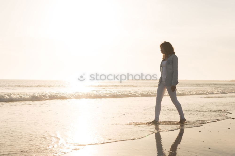 Similar – Woman on the beach looking at the horizon