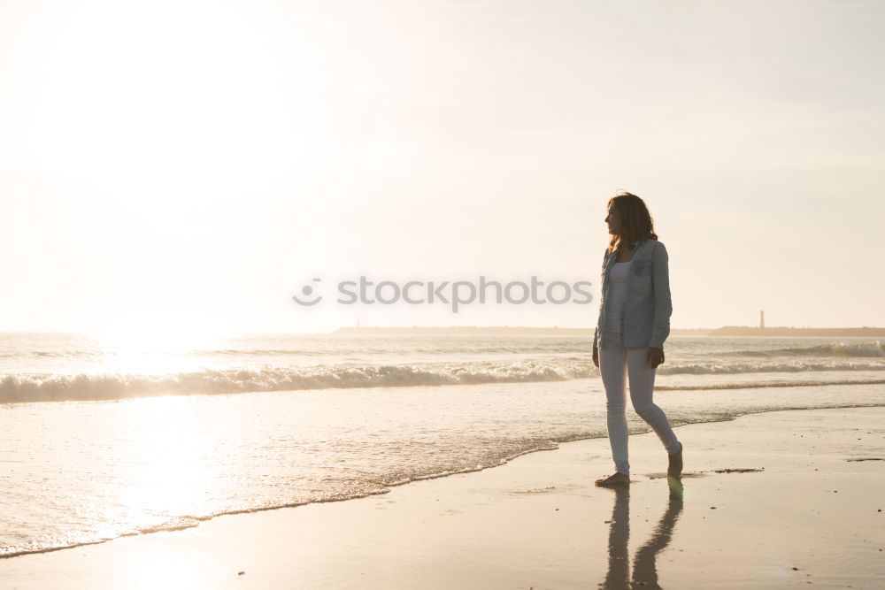 Similar – Woman on the beach looking at the horizon