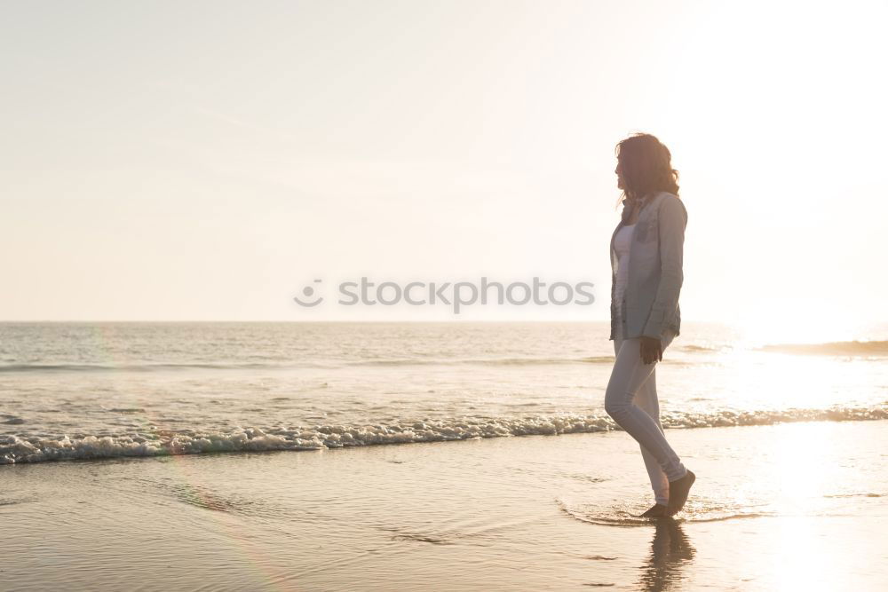 Similar – Woman on the beach looking at the horizon