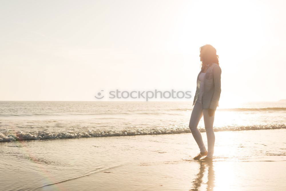 Similar – Woman on the beach looking at the horizon