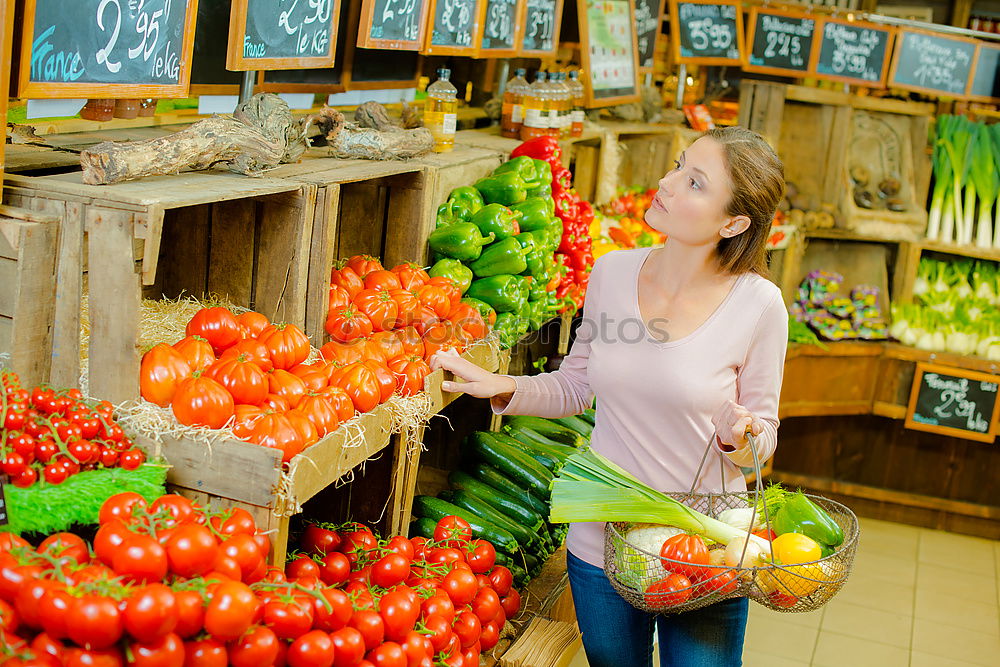 Similar – Image, Stock Photo Young woman shopping for fresh tomatoes at an open-air stall choosing items from a row of wooden boxes