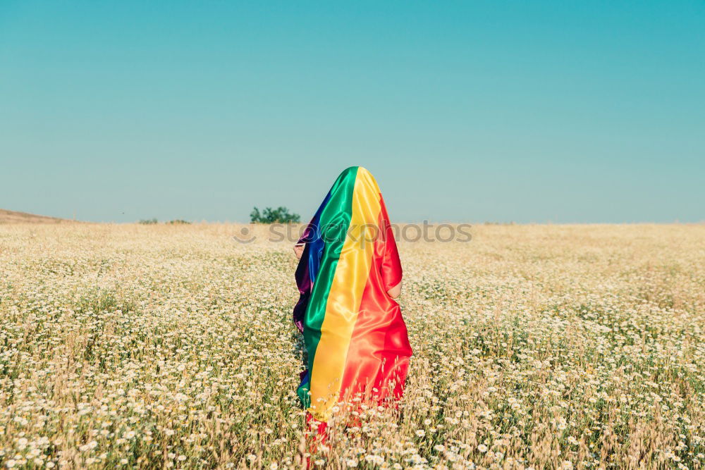 Similar – Image, Stock Photo Young woman holding a rainbow flag behind a fence