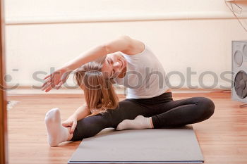 Similar – Group of young sporty attractive women in yoga studio, practicing yoga lesson with instructor, sitting on floor in forward bend yoga sana posture. Healthy active lifestyle, working out indoors in gym