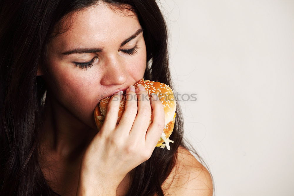 Similar – Woman taking bite of hamburger in restaurant