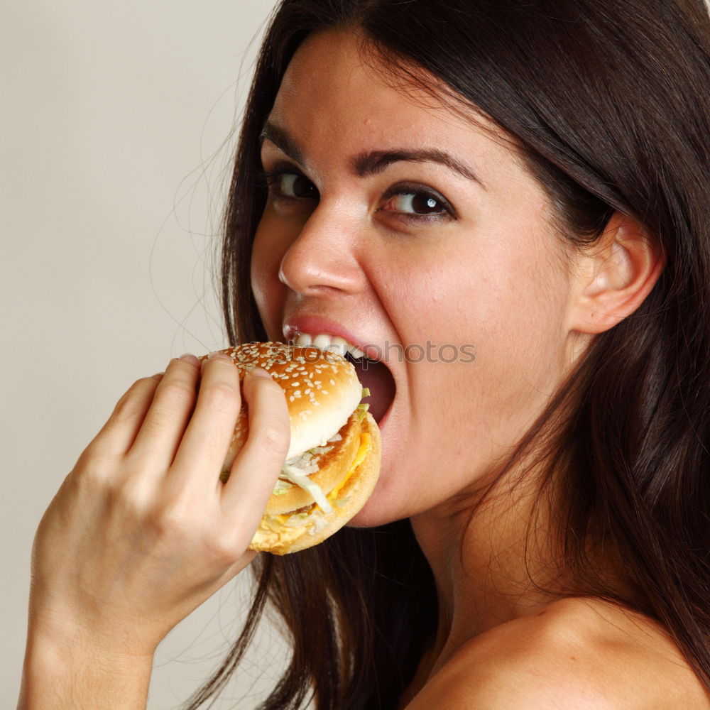 Similar – Woman taking bite of hamburger in restaurant