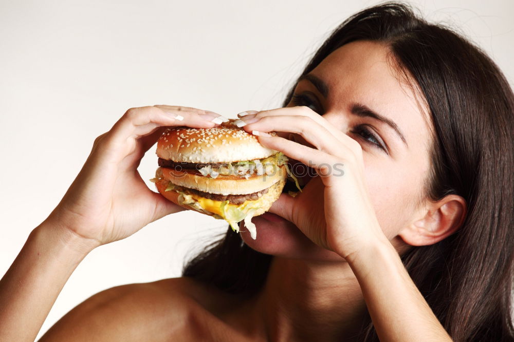 Similar – Woman taking bite of hamburger in restaurant