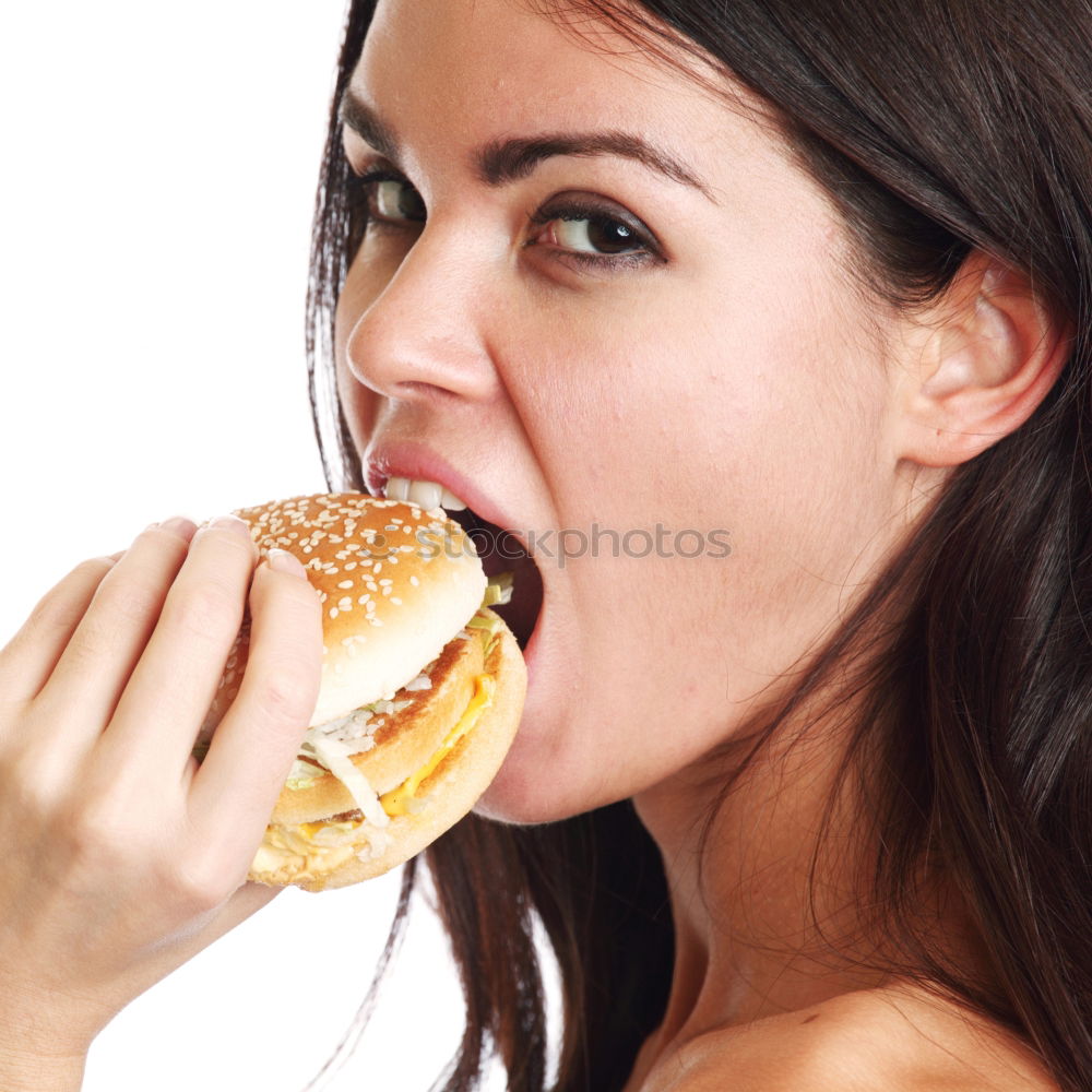 Woman taking bite of hamburger in restaurant