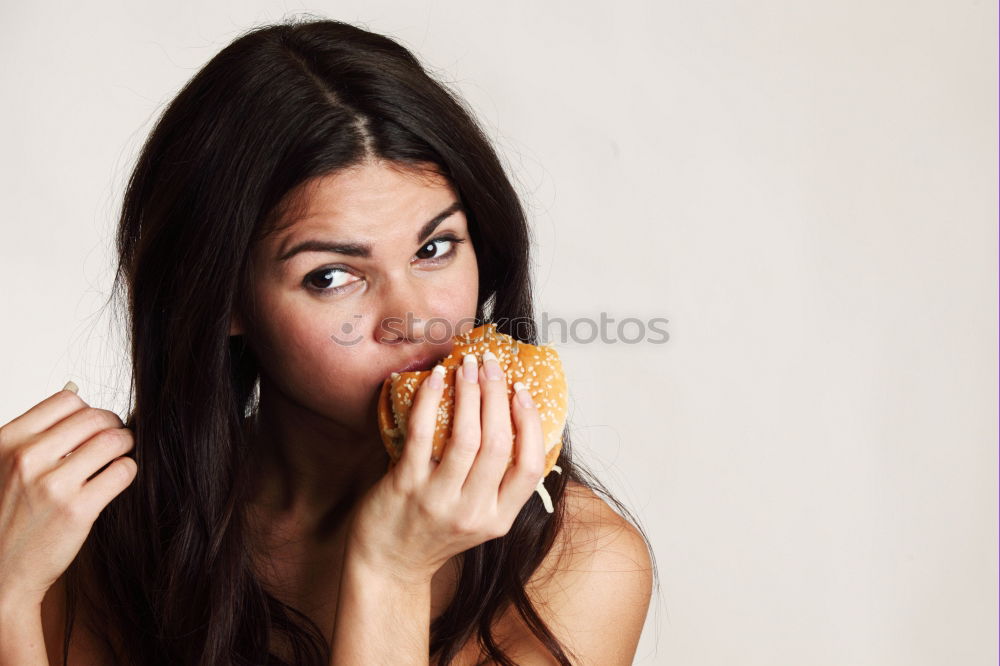 Similar – Woman taking bite of hamburger in restaurant