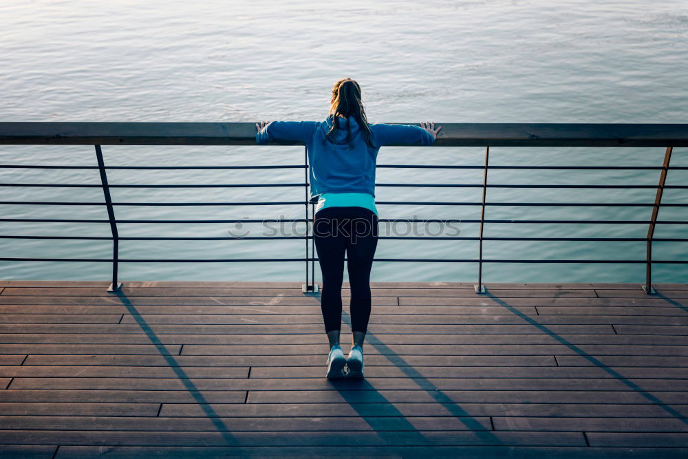 Young fitness woman runner running on city bridge.