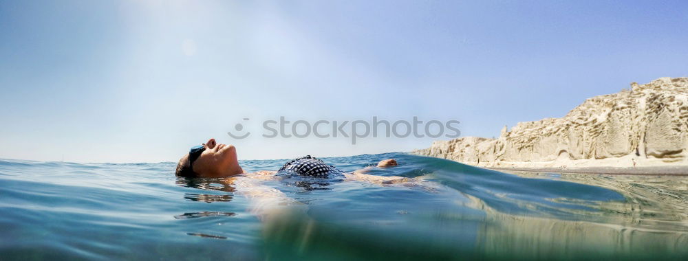 Similar – Little boy floating on the sea with transparent water