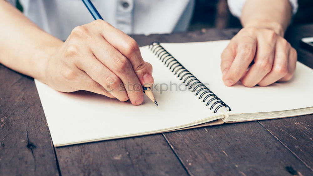 Similar – A woman’s hand holding an empty notebook