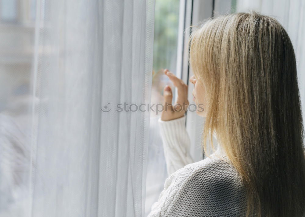 Similar – Dreaming girl looking away in window