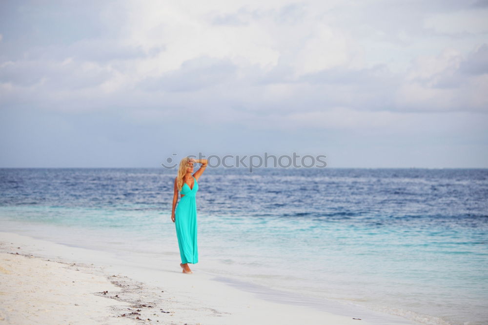 Similar – young nude girl with a hat walks on an empty beach near the sea surf against the blue sky with clouds in summer