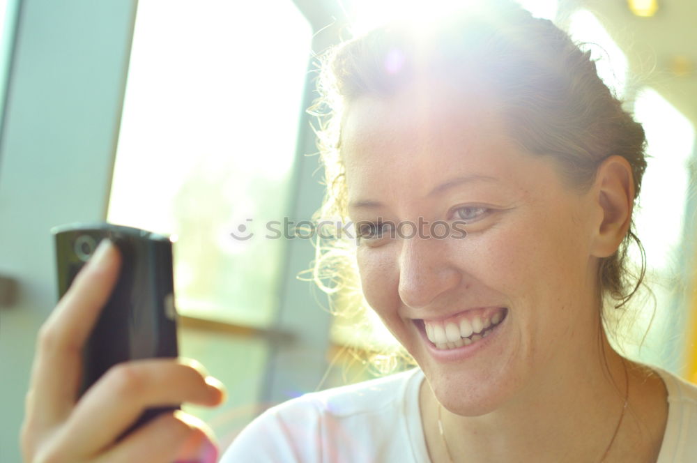 Similar – Young happy woman with green jacket taking selfie with her smartphone on the beach at sunset