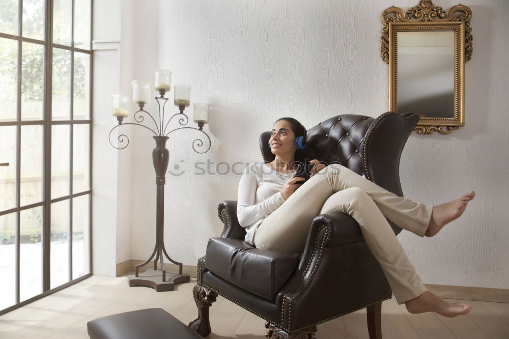 Similar – Young, tall, slim female student sits on a chair at her desk and laughs into the camera