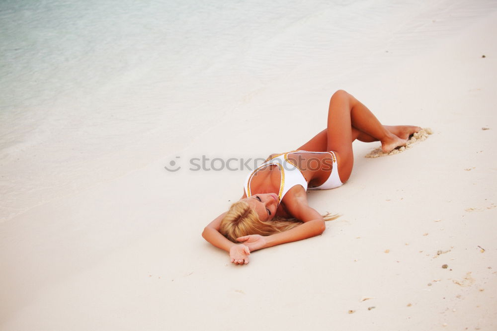 Similar – Beautiful girl lying at the beach in her swimsuit and reading a book