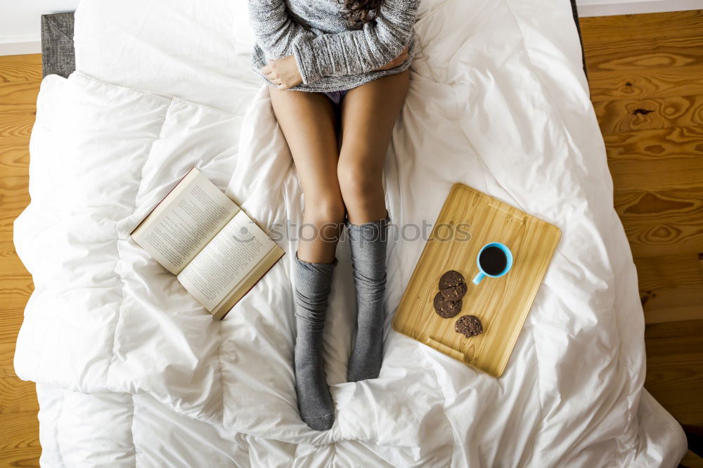 Similar – Weiches Foto von Frauenbeinen auf dem Bett mit einem alten Buch neben ihr