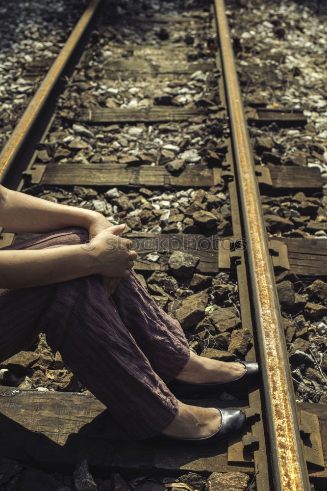 Similar – Sad girl teenager sitting on rusty rail track outside the town. Escape to be alone