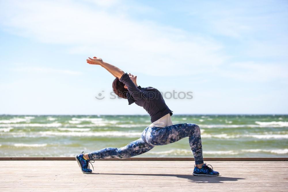 Black woman, afro hairstyle, doing yoga in the beach.