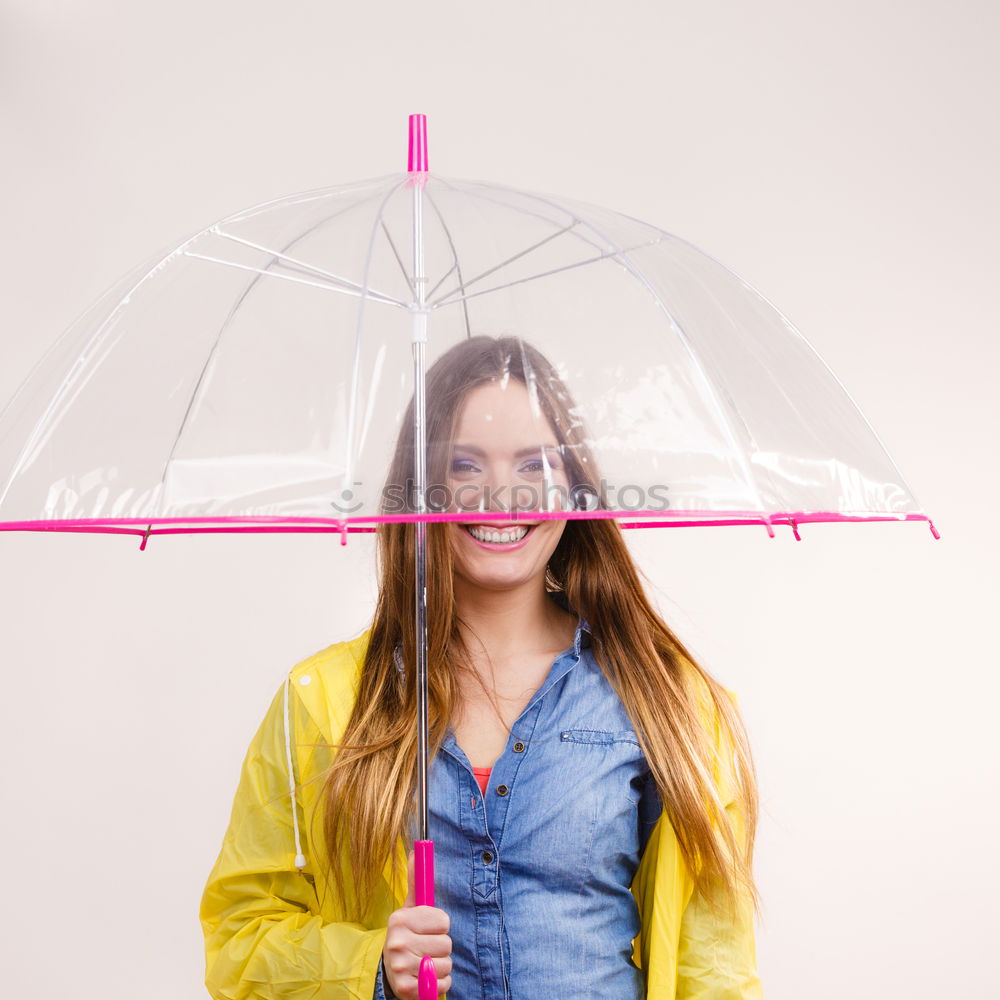 Woman with umbrella in front of green wall