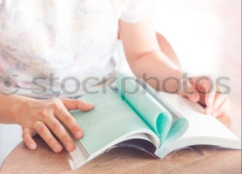 Similar – Image, Stock Photo Young girl turning the pages of book in bookstore