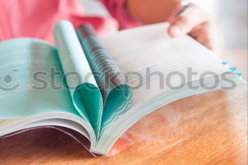 Similar – Image, Stock Photo Young girl turning the pages of book in bookstore